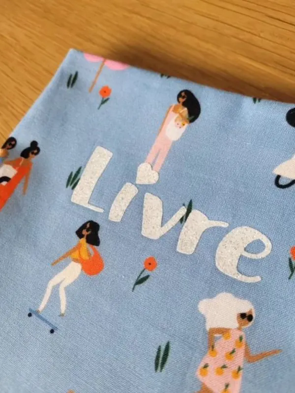 Pochette en tissu illustré brodée du mot « Livre »